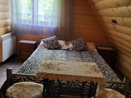 a bed in a wooden room with a table and a bed sidx sidx sidx at Wynajem Pokoi Krystyna Mróz in Zakopane