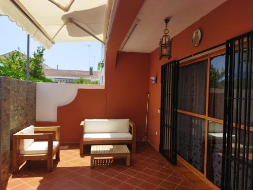 eine Terrasse mit einem Sofa, einem Stuhl und einem Tisch in der Unterkunft Sol y Mar in Isla Cristina