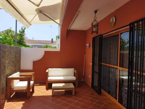 patio con sofá, silla y mesa en Sol y Mar, en Isla Cristina