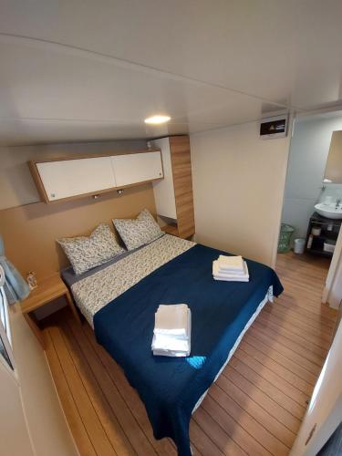 a bedroom with a bed with two towels on it at Philomena Mobile home Camping Pasman in Pašman