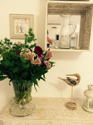 un vase de fleurs sur une table avec un miroir dans l'établissement Studio Chateau - Vieux Nice, à Nice