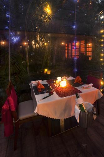 a table in a restaurant with a candle on it at Sea Shell Coral Cove in Port Blair