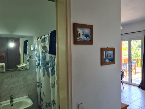 a bathroom with a shower and a sink and a mirror at SPITIKARIOTIKO Panoramic Home in Raches
