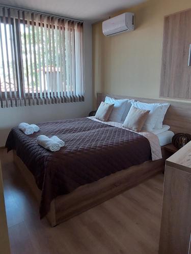 a bedroom with a large bed with two towels on it at Studio Paradise - Near Tsarevets&Central Location in Veliko Tŭrnovo