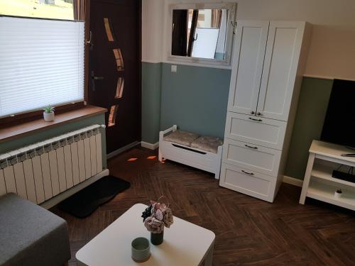 a living room with a couch and a table at Apartamenty Tylicki Poranek in Tylicz