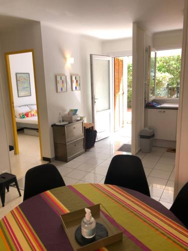 un salon avec une table et des chaises et une chambre dans l'établissement BEL APPARTEMENT 4Pers RDC/parking/terrasse/ jardin, à Collioure