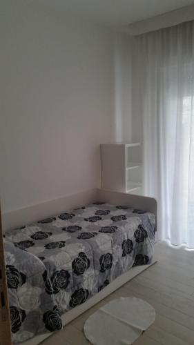 a bed in a white room with a bedspread at Michelangelo rta in Cinquale