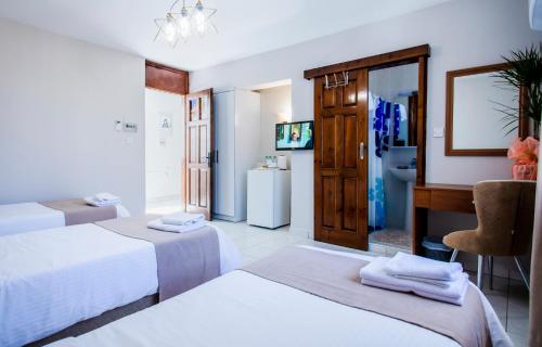 a hotel room with two beds and a bathroom at Homelike Guest house in Kyrenia