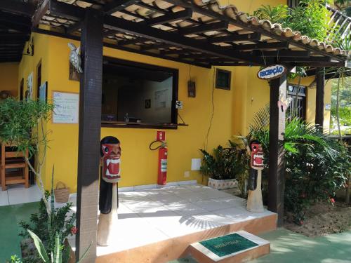 a yellow building with a fire hydrant in front of it at Pousada Canto De Imbassai in Imbassai