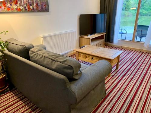a living room with a couch and a tv at TheWaterfrontLodges in Coventry