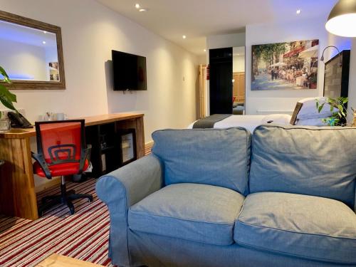 a living room with a blue couch and a bed at TheWaterfrontLodges in Coventry