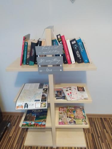 a book shelf filled with books and magazines at Apartament przy Fontannie Neptuna in Gdańsk