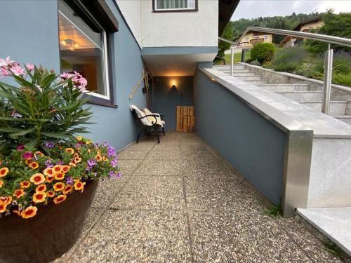 einen Gehweg mit Blumen in einem Topf neben einem Gebäude in der Unterkunft Haus Nocky Mountains in Radenthein