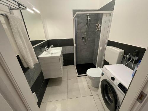 a bathroom with a shower toilet and a washing machine at Casa Beach in Balestrate