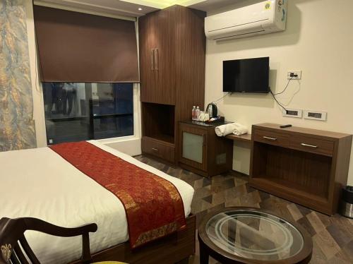 a hotel room with a bed and a flat screen tv at Trimrooms Triumph Banaras Railway Station in Varanasi