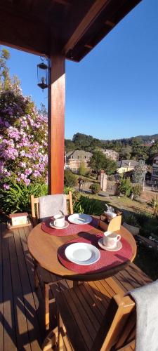 - une table en bois sur une terrasse avec une table dans l'établissement Chalés Lanelli, à Monte Verde
