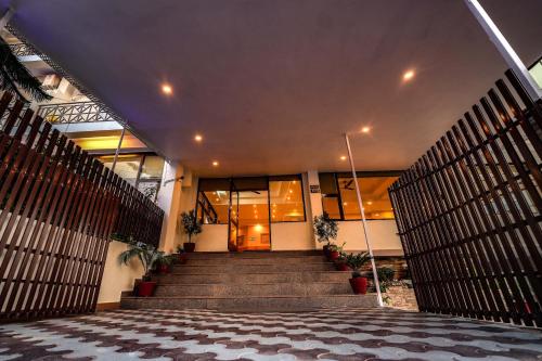 a lobby of a building with stairs and a building at Hotel 360 by D'Polo Dharamshala in Dharmsala
