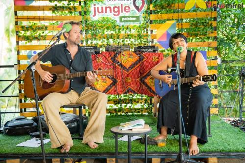 un hombre y una mujer tocando guitarras y micrófonos en Jungle by sturmfrei Palolem en Palolem