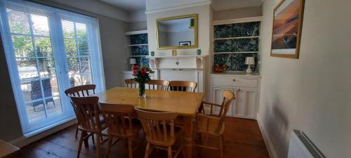 a dining room with a table and chairs and a window at Dumble Cottage in Minehead