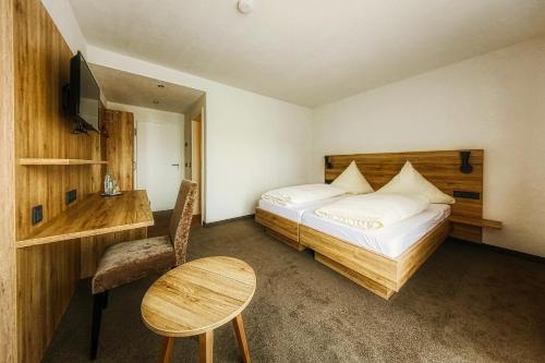 a bedroom with a bed and a desk and a table at Beim Mühlenwirt in Bobenthal