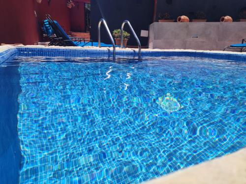 a large blue swimming pool with blue water at Casa La Gollada in Cazadores