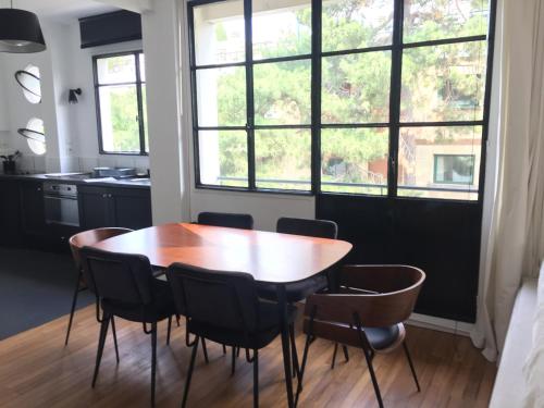 cocina con mesa de madera, sillas y ventana en Numéro 5 en Boulogne-Billancourt