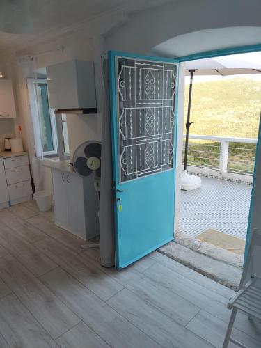 eine blaue Tür in einer Küche mit Fenster in der Unterkunft STATHIS GUESTHOUSE in Lefkada Town