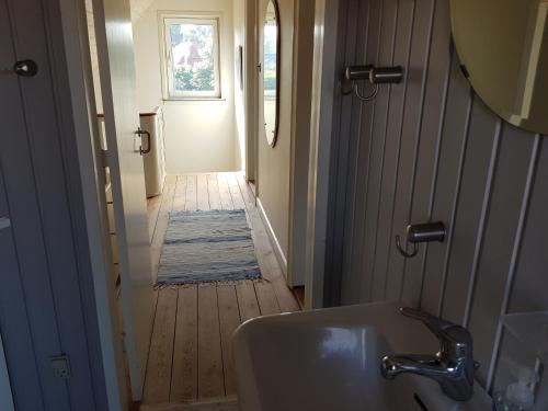 a bathroom with a sink and a hallway with a door at Hus til stor familie in Bredebro