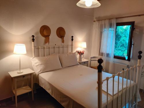 1 dormitorio con cama blanca y ventana en Armonia & Anemos Family Apartments, en Kálamos