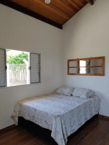 Schlafzimmer mit einem Bett und einem Fenster in der Unterkunft Pousada e Cervejaria Amor in Malte in Lavrinhas