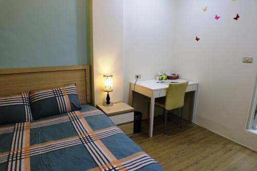 a bedroom with a bed and a desk and a table at Xiangsheng Homestay in Puli