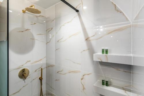 a bathroom with white marble walls and a shower at AGNONTAS LUXURY VILLAS in Agnontas