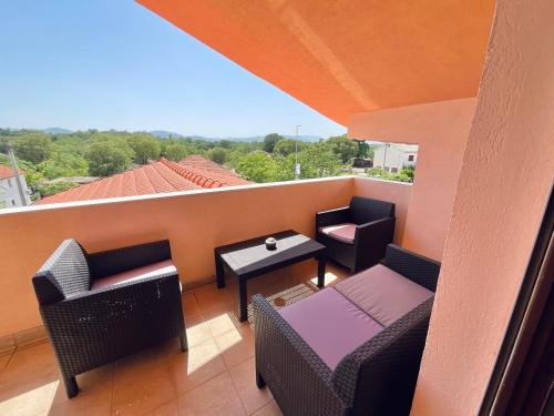 d'un balcon sur le toit avec des chaises et des tables. dans l'établissement Apartment Camellia, à Ljubuški