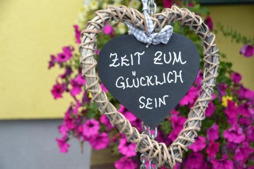 a heart shaped sign in front of flowers at ERLEBNISBAUERNHOF Steinerhof in Kärnten in Liebenfels