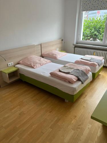 two beds in a room with wooden floors at Waffel Cafe HOSTEL Monteurwohnung Ferienwohnung in Kassel