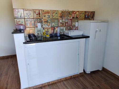 a white kitchen with a sink and a refrigerator at Pousada e Cervejaria Amor in Malte in Lavrinhas