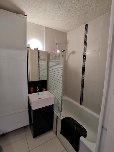 une salle de bain blanche avec un lavabo et une douche dans l'établissement Appartement - Combloux, à Combloux