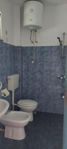 a bathroom with two toilets and a sink at Villa Madani in Durrës