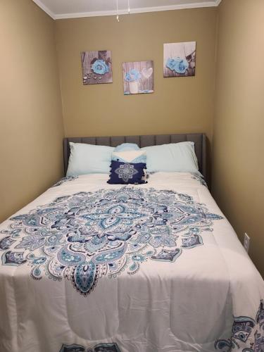 a bed with a blue and white blanket on it at JAMMS tiny home in Baton Rouge