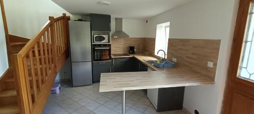 cocina con encimera de madera y fregadero en Gite de POUNARD bord de rivière plage privée 