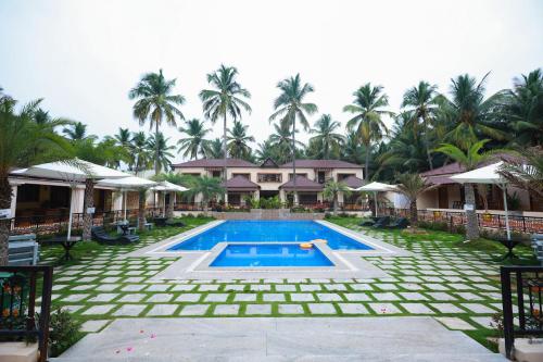 a resort with a swimming pool and palm trees at Royal Destiny Resort in Malaiyāndipattanam