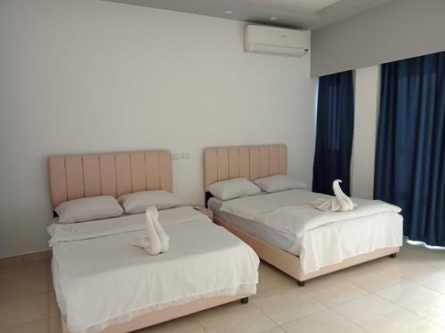 two beds in a room with blue curtains at Jasmine Resort & Aqua park in Sharm El Sheikh