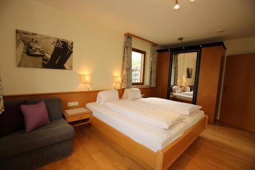 a bedroom with a large bed and a couch at Haus Alexander in Schladming