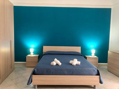 - une chambre bleue avec un lit et 2 serviettes dans l'établissement Sofi House, à Santo Stefano di Camastra