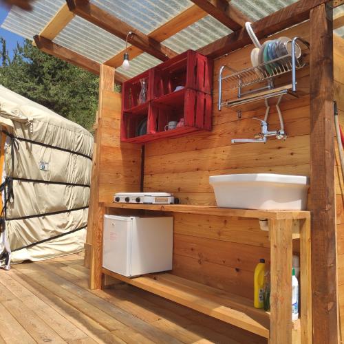 a kitchen in a wooden house with a sink at Glamping la Cascina d'Orleans in Saint-Pierre