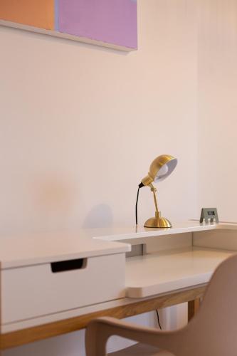 a desk with a lamp and a chair on it at Votre Maison Loin de Chez Vous in Châteaugay