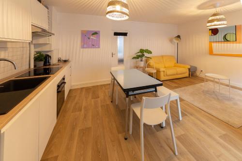 una cucina e un soggiorno con tavolo e sedie di Votre Maison Loin de Chez Vous a Châteaugay