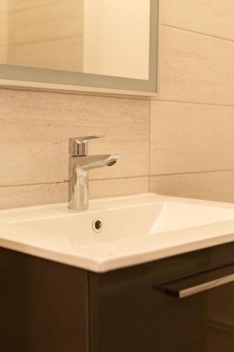 a white sink in a bathroom with a mirror at Votre Maison Loin de Chez Vous in Châteaugay