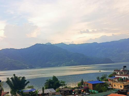 una vista di un grande specchio d'acqua con montagne di HOTEL LUMA INN a Pokhara