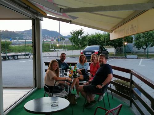 a group of people sitting at a table on a patio at Hostel Poslon in Krapina